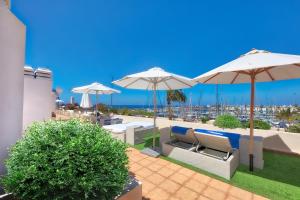 a patio with umbrellas and a view of a city at Hotel LIVVO Puerto de Mogán in Puerto de Mogán