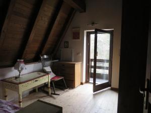 オヴィンドリにあるtipica baita con vista sul monte magnolaのデスクと窓が備わる屋根裏部屋