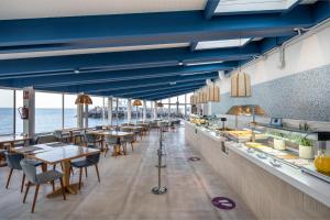 a restaurant with blue ceilings and tables and chairs at Hotel LIVVO Puerto de Mogán in Puerto de Mogán