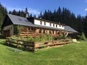 ein großes Haus mit einem Zaun davor in der Unterkunft Penzion Ida in Lenora