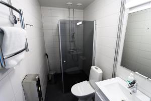 a bathroom with a shower and a toilet and a sink at Varala Nature Hotel & Sport Resort in Tampere