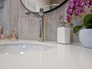 a bathroom sink with a faucet and flowers on a counter at Słoneczna Zatoka Gowidlino in Gowidlino