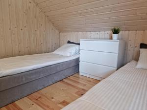 1 dormitorio con 2 camas en una habitación de madera en Słoneczna Zatoka Gowidlino en Gowidlino