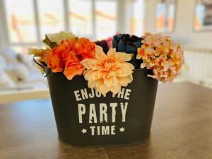a black bucket filled with flowers on a table at Playa Panjón in Nigrán
