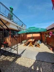 een patio met een tafel en een grote parasol bij CASA IV in Vama Veche