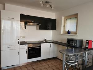 a kitchen with white cabinets and a black counter top at 7 Heaven in Eichenberg