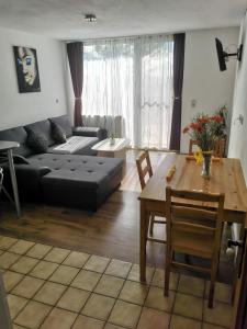 a living room with a black couch and a table at 7 Heaven in Eichenberg