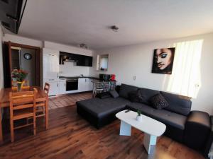 a living room with a black couch and a table at 7 Heaven in Eichenberg