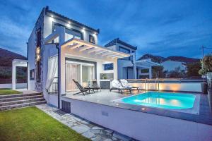 a house with a swimming pool in the backyard at JOY C Deluxe in Iraklitsa