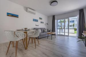 a living room with a table and chairs and a couch at Island Home Fuerteventura in Corralejo
