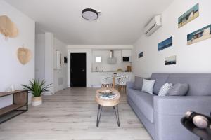 a living room with a blue couch and a table at Island Home Fuerteventura in Corralejo