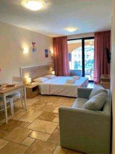 a bedroom with a bed and a couch and a table at Happy Studio Sea View in Topola