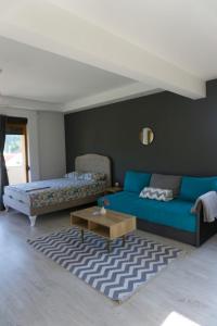 Apartments Ena في تريبينيي: غرفة معيشة مع أريكة زرقاء وطاولة