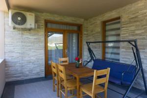 a wooden table and chairs on a patio at Apartments Ena in Trebinje
