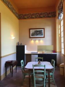 a dining room with a table and chairs and a counter at Chambres d'Hôtes & Gites La Chatellenie in Saint-Aubin-le-Cauf