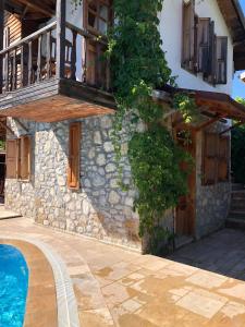 a house with a balcony and a swimming pool at Olympos Koyevi Countryhouse in Olympos