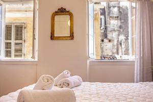 een slaapkamer met een bed, een spiegel en een raam bij Downtown Apt at Filellinon in Corfu-stad