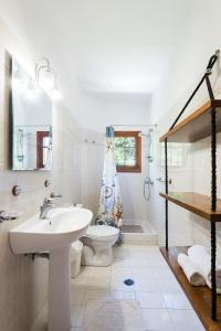 un bagno bianco con lavandino e WC di Villa Sole Mare a Pefki Rhodes