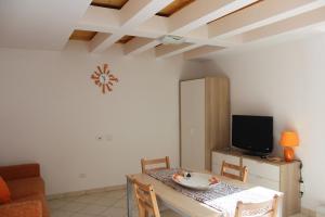 ein Esszimmer mit einem Tisch und einem TV in der Unterkunft Casa Mirna in Rio nellʼElba