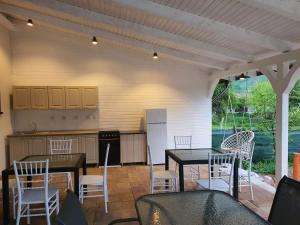 a patio with tables and chairs and a kitchen at Casa Artemis-jacuzzi și piscină in Pianu de Sus