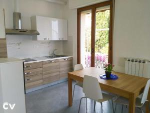 Appartamento Caterina Finale Ligure في فينالي ليغوري: مطبخ مع طاولة خشبية وطاولة وكراسي