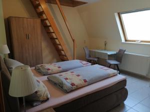 a bedroom with two beds and a table and a window at Gästehaus Herbert Kappes in Zeltingen-Rachtig