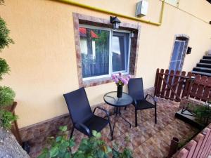 a patio with three chairs and a table with flowers on it at Apartament Dilama Sinaia in Sinaia