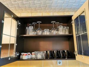 a shelf with glasses on it in a kitchen at Apartament Dilama Sinaia in Sinaia