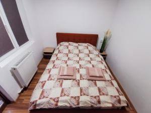 a bed with a quilt on it in a room at Apartament Dilama Sinaia in Sinaia