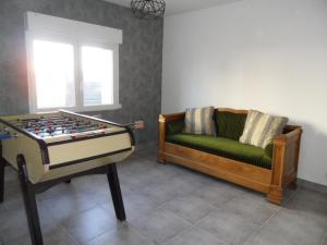 ein Wohnzimmer mit Sofa und Tischfußball in der Unterkunft logement entre mer et montagne in Roujan