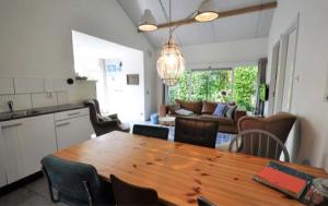 een keuken en een woonkamer met een houten tafel en stoelen bij De Zandput 23 Zoutelande in Zoutelande
