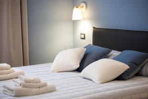 
a bed with a white comforter and pillows at Al Vicolo tre in Sassari
