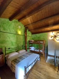 two beds in a room with green walls and wooden ceilings at CASINA LA QUERCIA in Santa Sofia