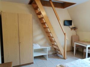 a room with a staircase with a desk and a tv at Gästehaus Herbert Kappes in Zeltingen-Rachtig
