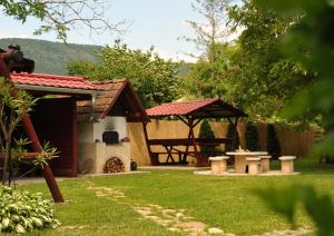 a backyard with a picnic table and a picnic shelter at Diókert Vendégház in Komjáti