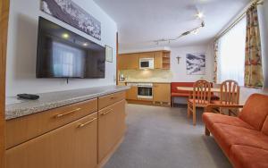 a kitchen with a television and a dining room at Appartements 4-You in Saalbach-Hinterglemm