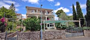 a house with a stone wall and a fence at Apartments 1000 Flowers in Stari Grad