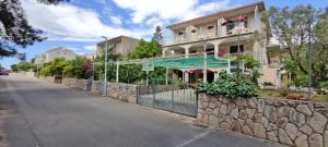 a building with a stone wall next to a street at Apartments 1000 Flowers in Stari Grad