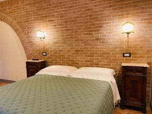 a bedroom with a bed and a brick wall at B&B Il Rosmarino in San Miniato