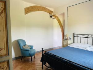 a bedroom with a bed and a blue chair at B&B Il Rosmarino in San Miniato
