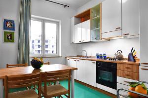 a kitchen with white cabinets and a wooden table at Caruso 1 - Sorrento in Sorrento