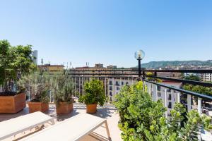 uma varanda com bancos e plantas num edifício em N'Attic a Vomero Penthouse Terrace by Napoliapartments em Nápoles