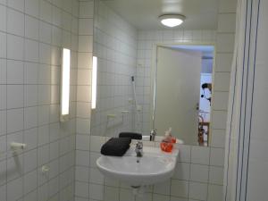 un bagno bianco con lavandino e specchio di Sangis Motell och Camping a Sangis Altre 74 foto