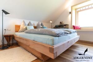 um quarto com uma grande cama de madeira com almofadas em Adlernest em Ramsau am Dachstein