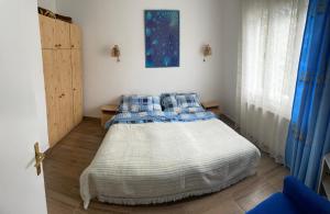 a bedroom with a bed with blue and white pillows at Széplaki Nyár Vendégház in Siófok