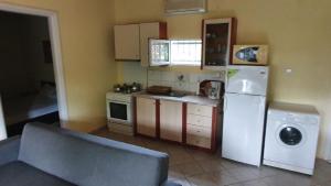 a kitchen with a refrigerator and a washing machine at christos cottage! comfortable and quiet! in Keramotí