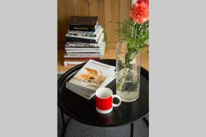 a table with a vase and a book and a cup of coffee at Cosy house by lake in Saku