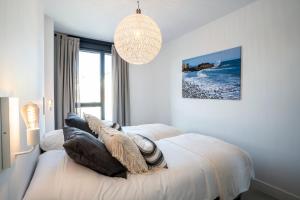 a bedroom with a bed with pillows and a chandelier at Sealine luxury apartment in Torrox Costa in Torrox Costa +39 photos