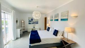 a bedroom with a large bed and a chandelier at Fonte Santa by Check-in Portugal in Quarteira