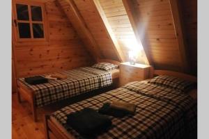a bedroom with two beds in a wooden cabin at Drinska Tisina in Ljubovija